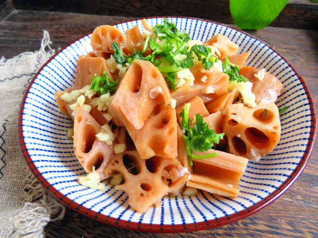 10,将藕段放入盘中,上面撒上蒜末和香菜,再淋上香油,生抽和醋拌匀就