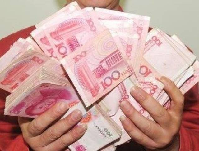 一沓一百面值的钞票,看见民警后,该女子走上前将手中的现金交给了出警