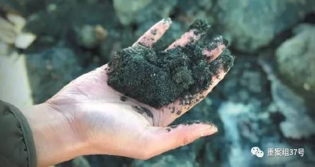 尾矿库用来筑坝的矿渣掉落在河道中,呈现蓝黑色,伴有异味.