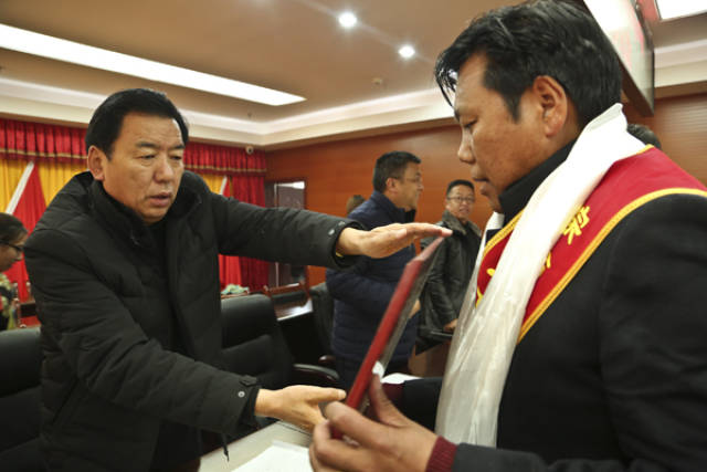 图为琼结县委副书记,县长索朗多吉正在为受表彰先进集体代表下水乡