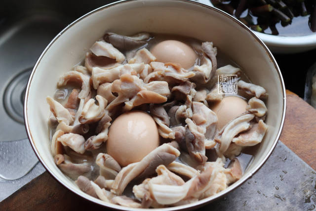 step8:用保鲜膜盖住碗口,高压锅里放上蒸架,倒入清水,把猪肚放入高压