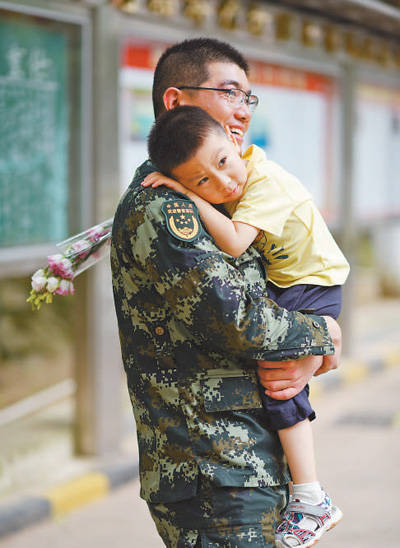 5月20日上午,深圳,3岁的"军娃"行行(化名)手持一束鲜花,走进武警广东