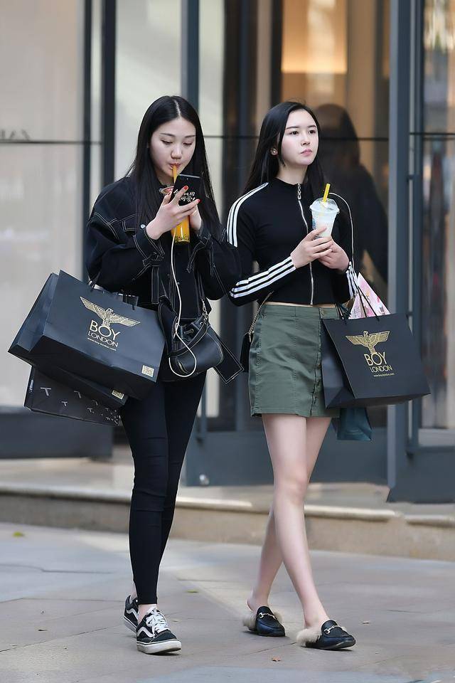 时尚街拍美女:黑色紧身牛仔裤的妹子和军绿色短裙的美女,小姐姐这大白