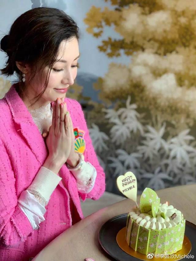 李嘉欣手里捧着生日蛋糕,笑容满面,明艳动人.