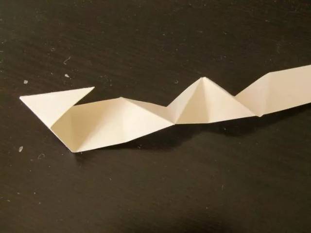 再折一道,边缘都要对齐,角也要保持尖尖的,叠得越规矩,做成的纸粽子才