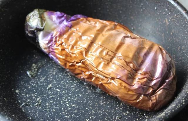 锅里放入少量的油, 把茄子放入锅中煎,要勤翻面,直到茄子变软, 蔫了