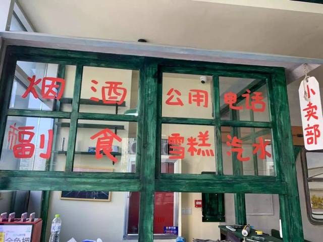 收银台是一个"小卖部" 绿色的木窗上写着"烟酒""公用电话" 再现80年代
