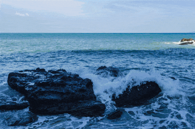 沿着栈道,伴着微风吹拂的海面,湛蓝的海水拍打着的岸边灰黑的岩石