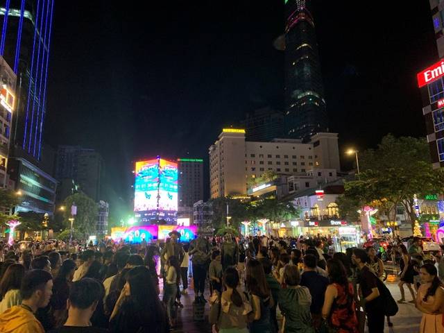 胡志明市中心晚上正在逛街的越南年轻人们