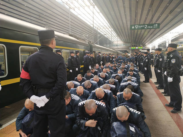 民警押解服刑人员在站台准备上车