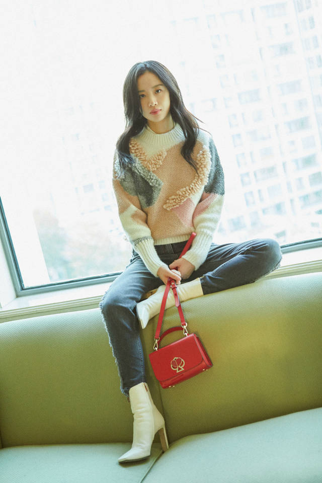 照片中,李梦置身于室内,身穿粉色拼接毛衣搭配修身牛仔裤,休闲舒适又