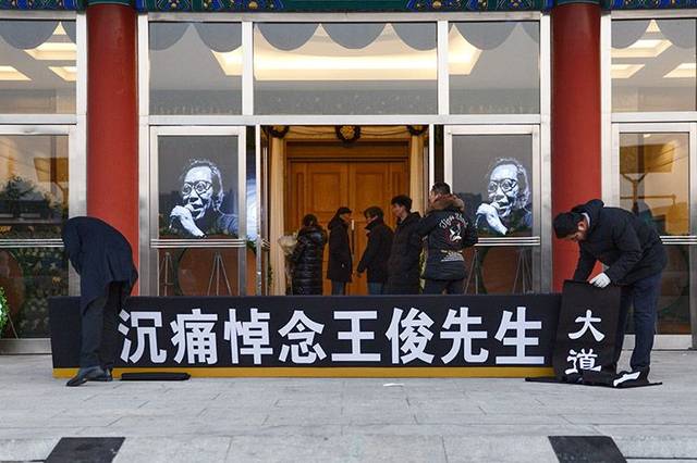 八宝山殡仪馆东礼堂,工作人员准备挂起挽幛.