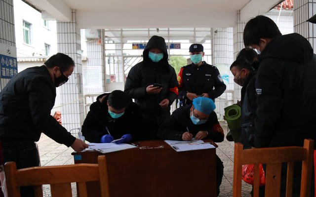 3月3日,葛云龙在出站口配合防疫人员对旅客进行信息登记.
