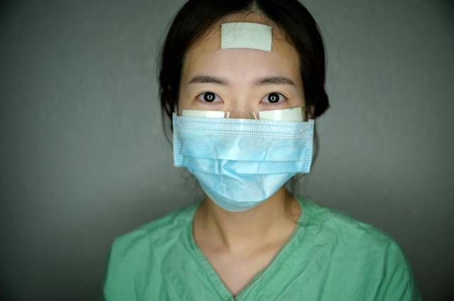 这些护士的脸上都贴上了胶布,绷带和护垫,可以保护脸部免受损伤,因为