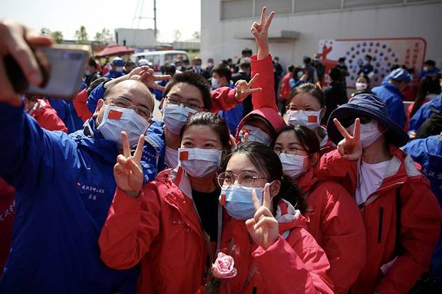 参加休舱仪式的医务人员在口罩上粘贴国旗.