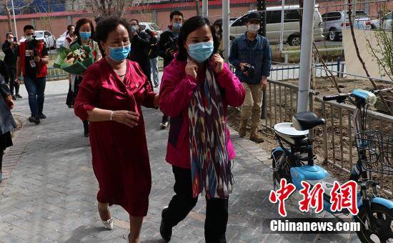 巴哈古丽·托勒恒与母亲金花·居玛德勒一起回家. 王小军 摄
