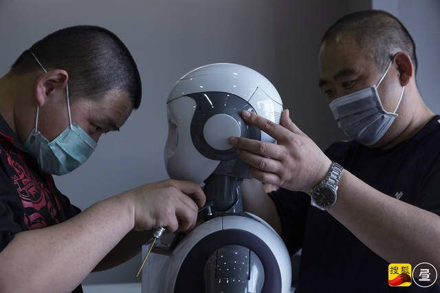 检测师在拆解机器人小方的头部,对其内部进行检测.