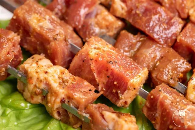 烤熟的牛肉粒串刚准备拿出来还冒着油花,滋啦啦作响.