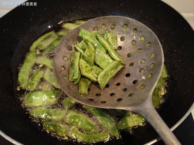 3.一直将芸豆炸到表皮呈虎皮色,颠起来变轻了,控油捞出.