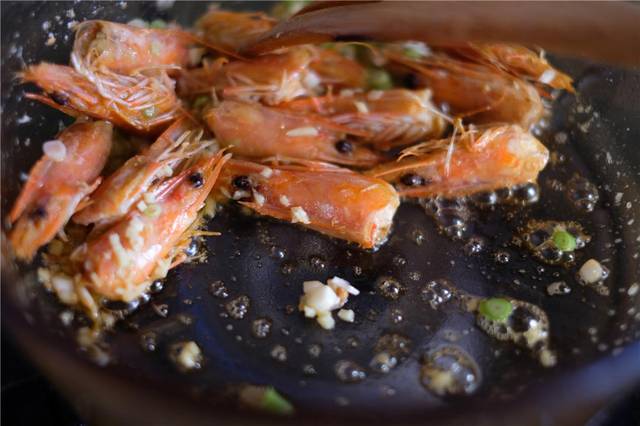 锅里热油,先放虾头煸炒出虾油